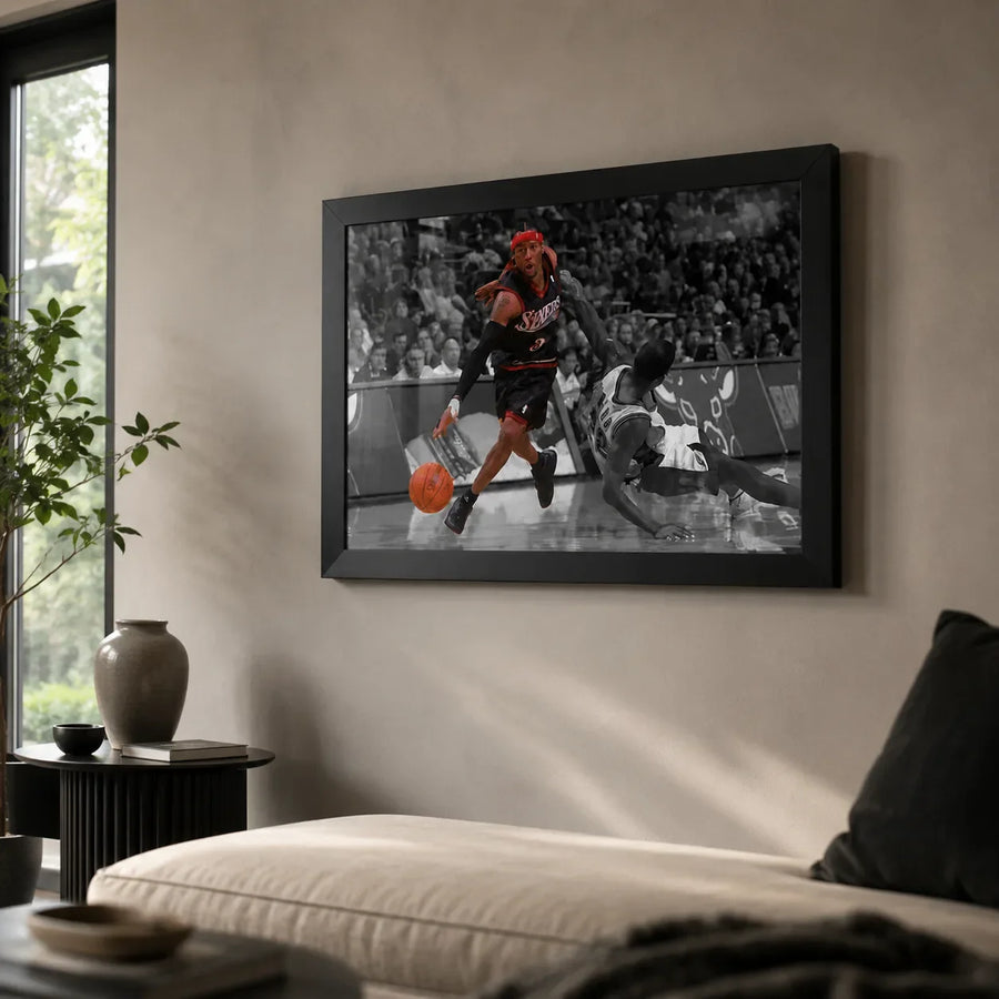 Allen Iverson crossover artwork in a black frame on a neutral living room wall above a light sofa.