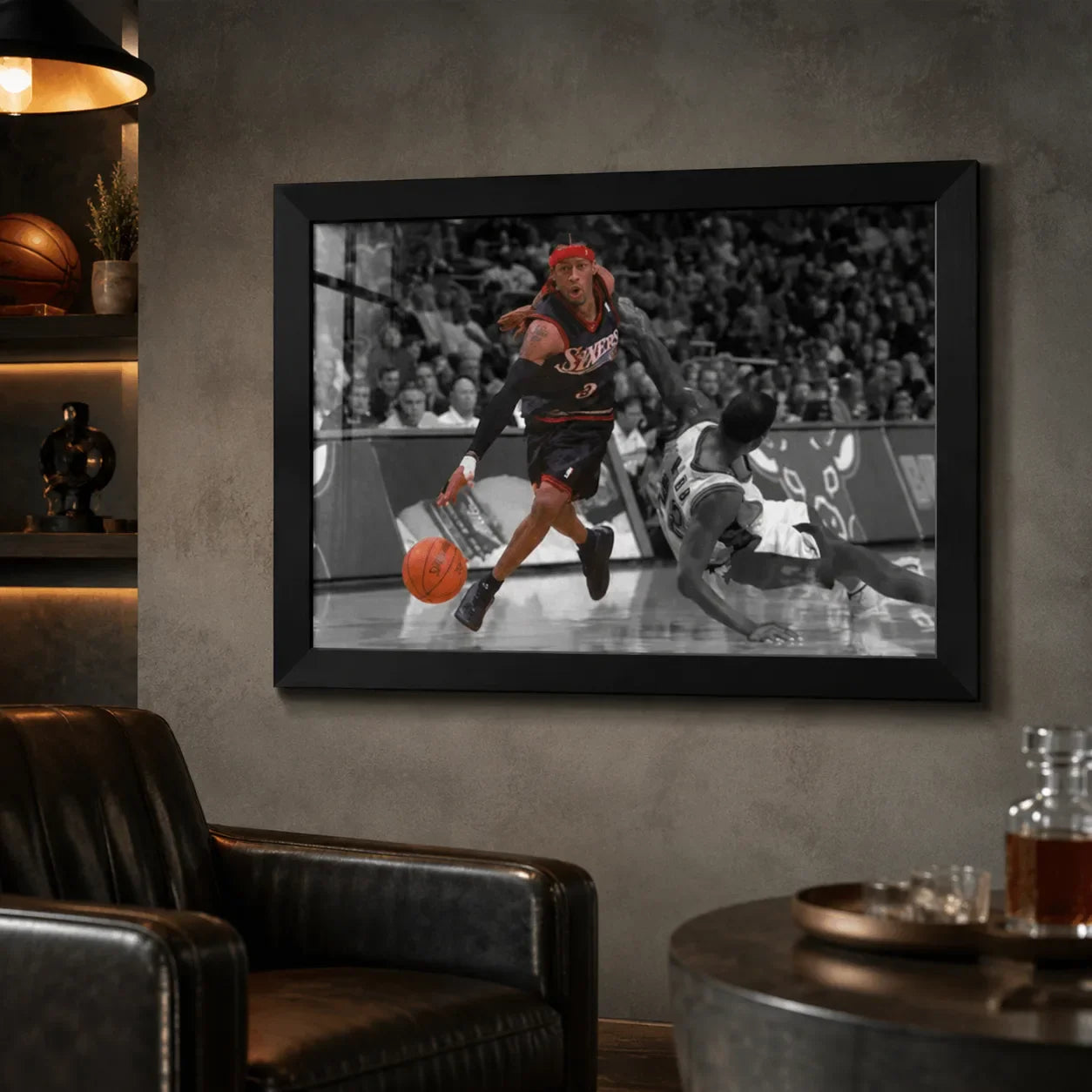 Black framed Allen Iverson crossover print displayed in a dark man cave with shelves and leather seating.