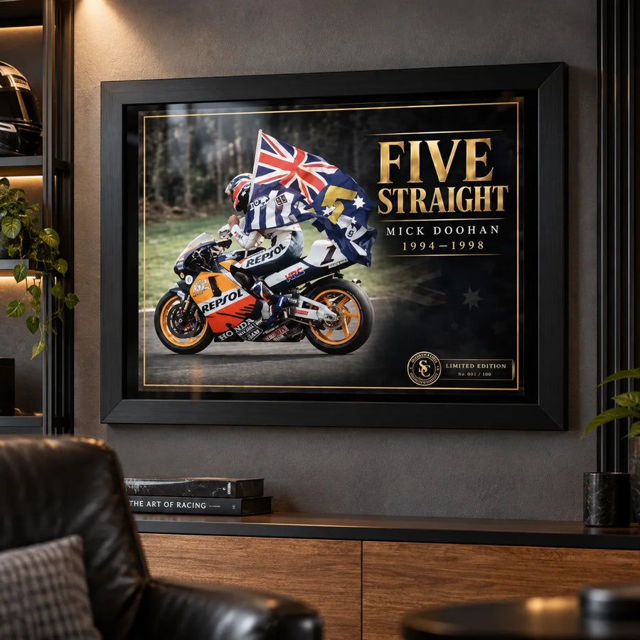 Mick Doohan Five Straight wall art displayed in a dark motorsport man cave with black frame and collector styling.