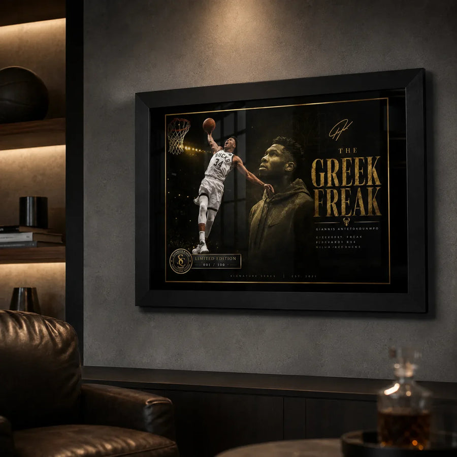 Giannis Antetokounmpo framed NBA wall art shown in a dark man cave lounge with shelves and leather chair.