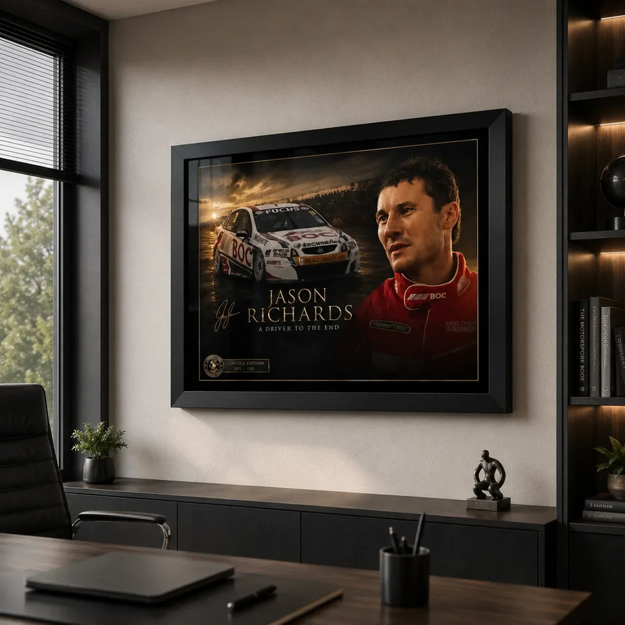 Black framed Jason Richards motorsport wall art displayed in a modern office above dark cabinetry and a timber desk.