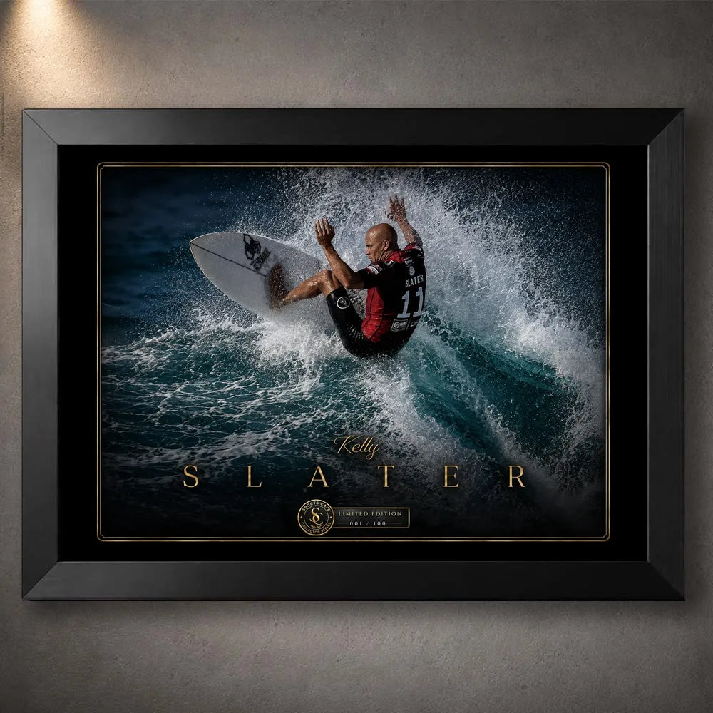 Black framed Kelly Slater surfing wall art showing a powerful turn through a breaking wave in a black and gold collector design.