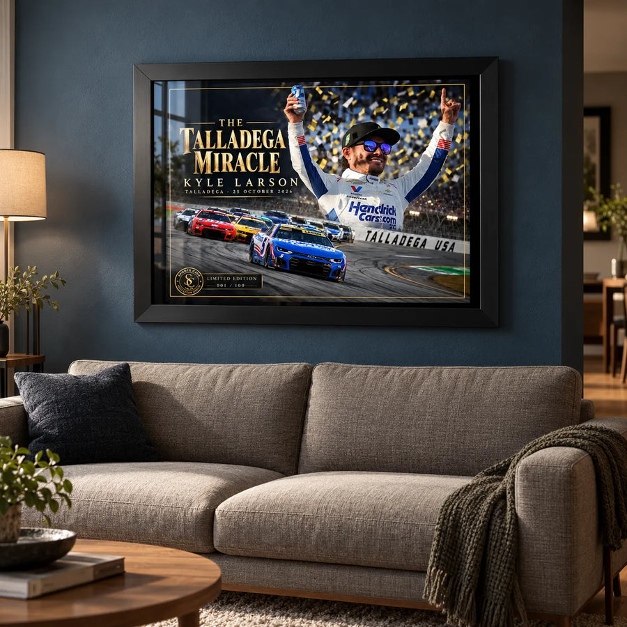 Kyle Larson The Talladega Miracle edition in a black frame above a fabric sofa against a blue living room wall.