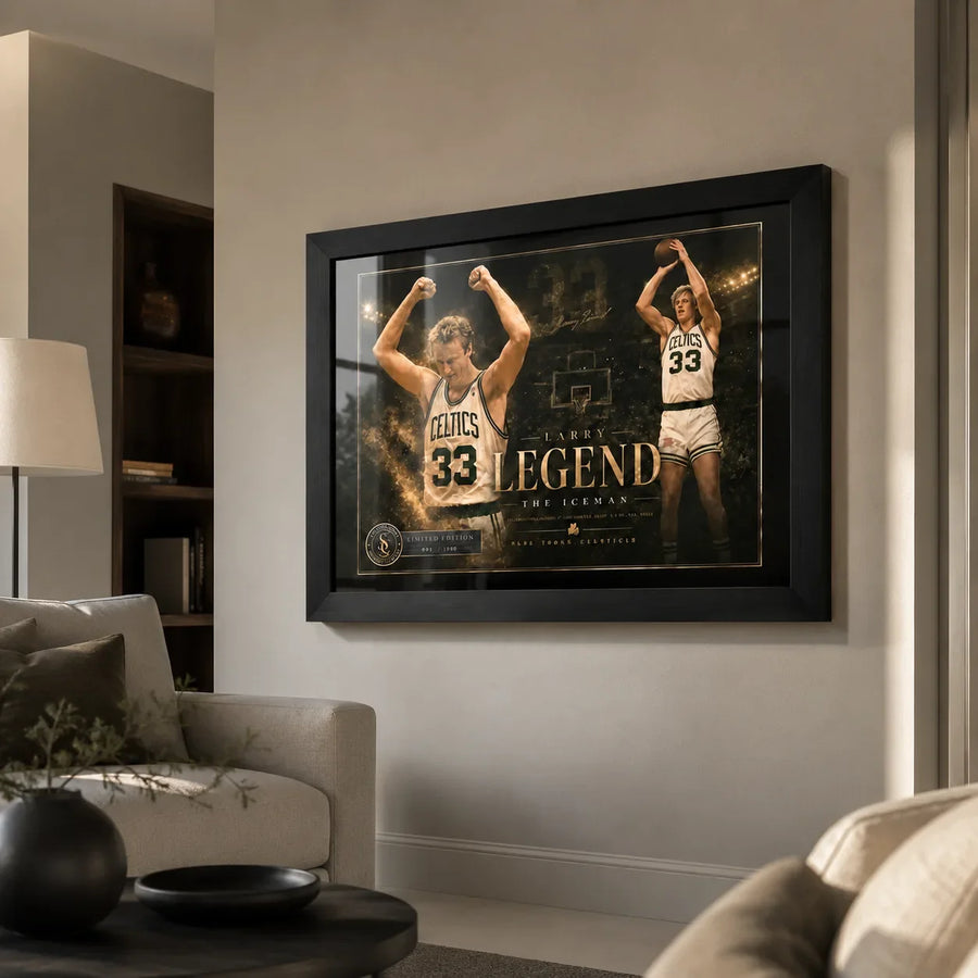Larry Bird wall art in black frame displayed in a premium living room above a neutral sofa and warm wall.