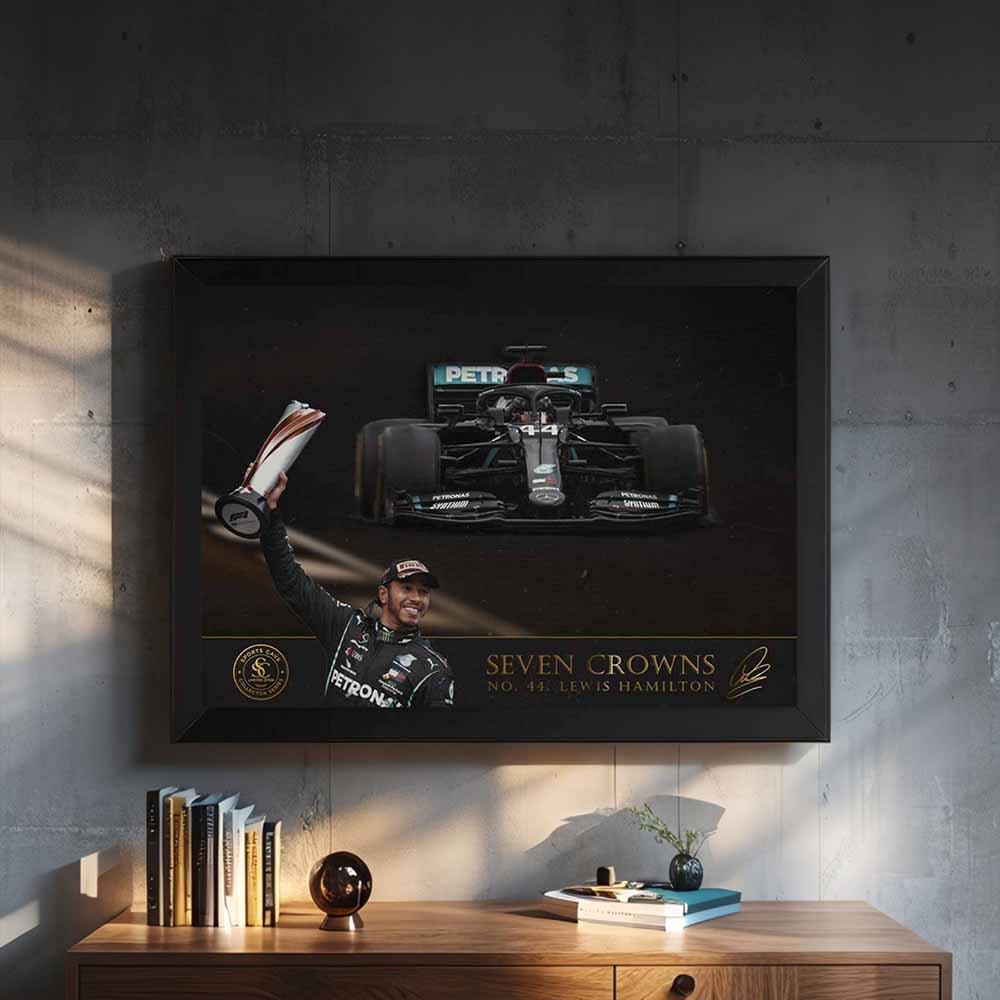 Framed poster of a Formula 1 wall art of Lewis Hamilton on a wall above a wooden shelf.