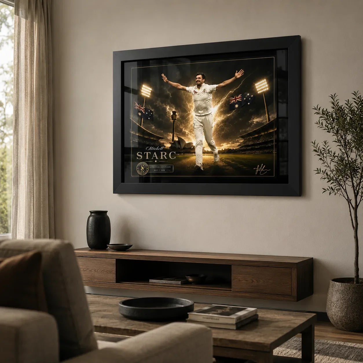 Black framed Mitchell Starc cricket wall art displayed above a timber console in a premium living room.