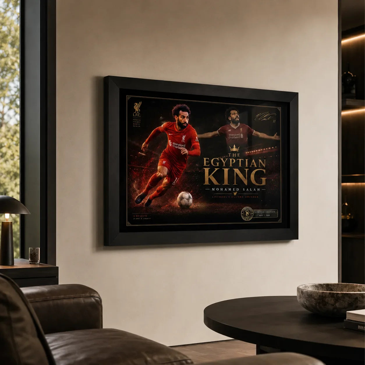 Black framed Mohamed Salah wall art displayed in a premium living room with warm neutral walls and leather seating.