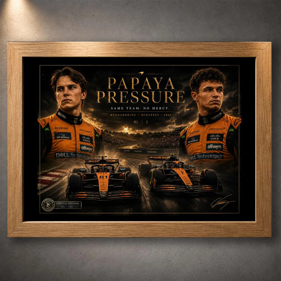 Oak framed Papaya Pressure Piastri vs Norris motorsport wall art shown against a textured grey wall.