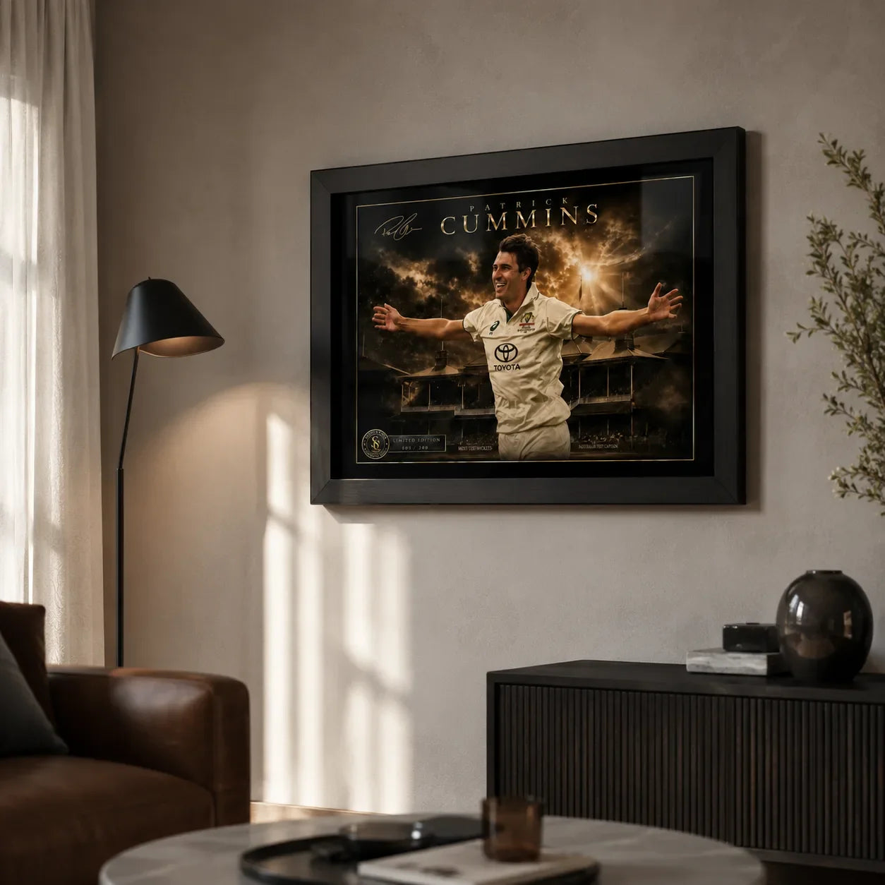 Pat Cummins cricket wall art in a black frame displayed in a warm modern living room with natural window light.