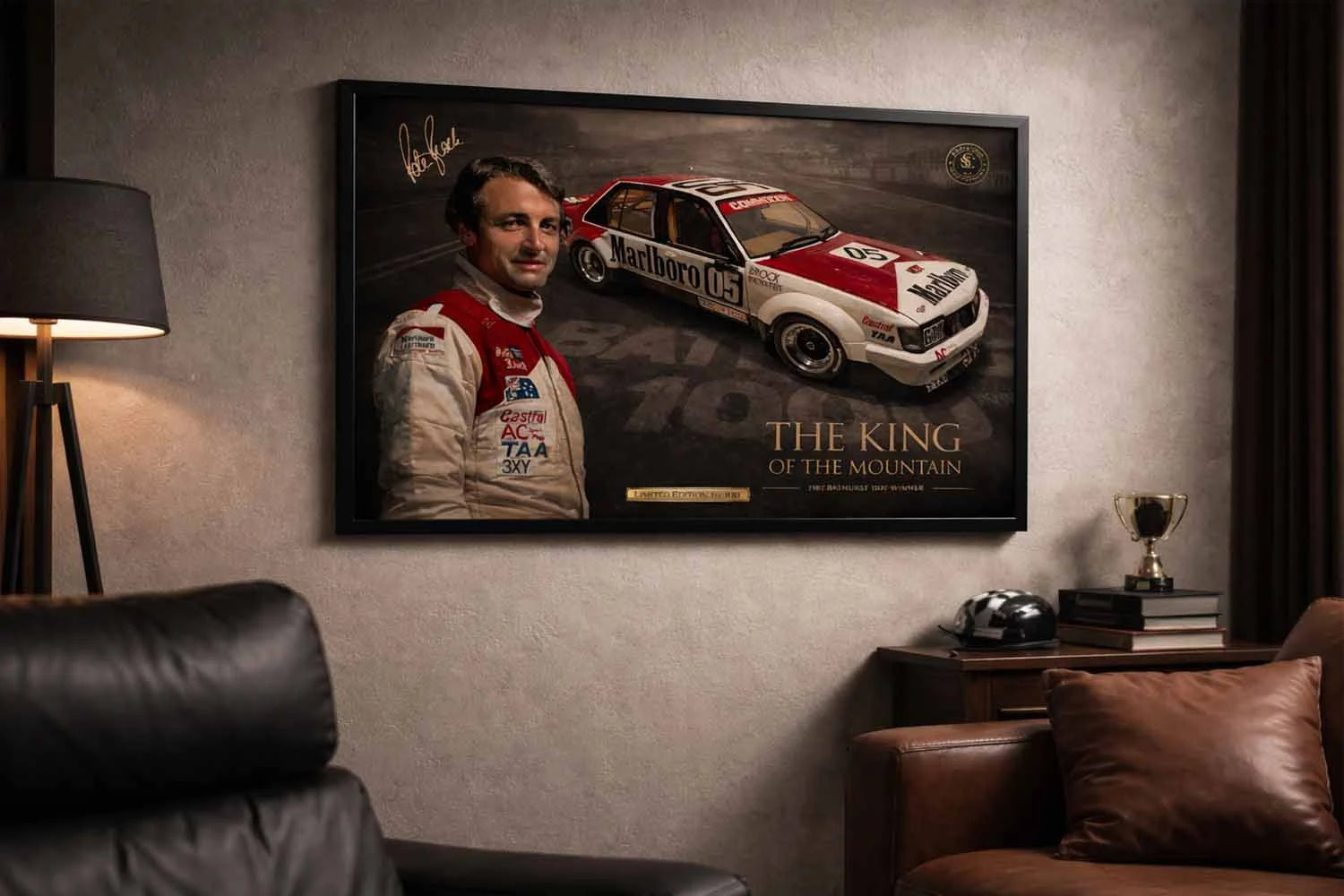 Peter Brock Bathurst 1000 Holden Commodore in black frame in a modern lounge, man cave wall décor above leather sofa.