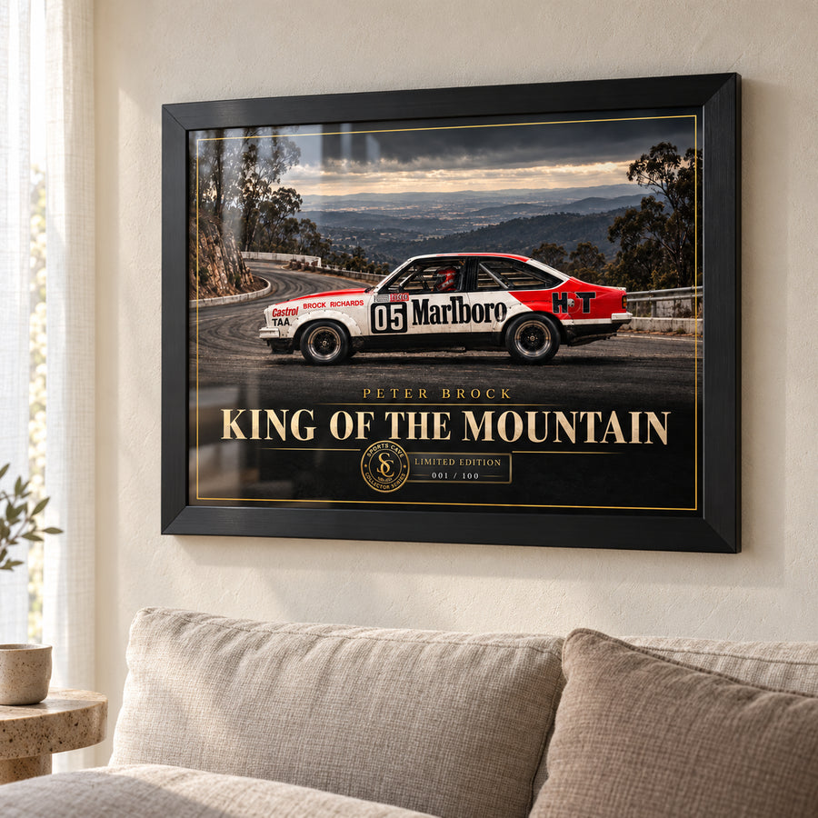 Peter Brock King of the Mountain wall art in a bright living room, displayed in a black frame above a neutral sofa.