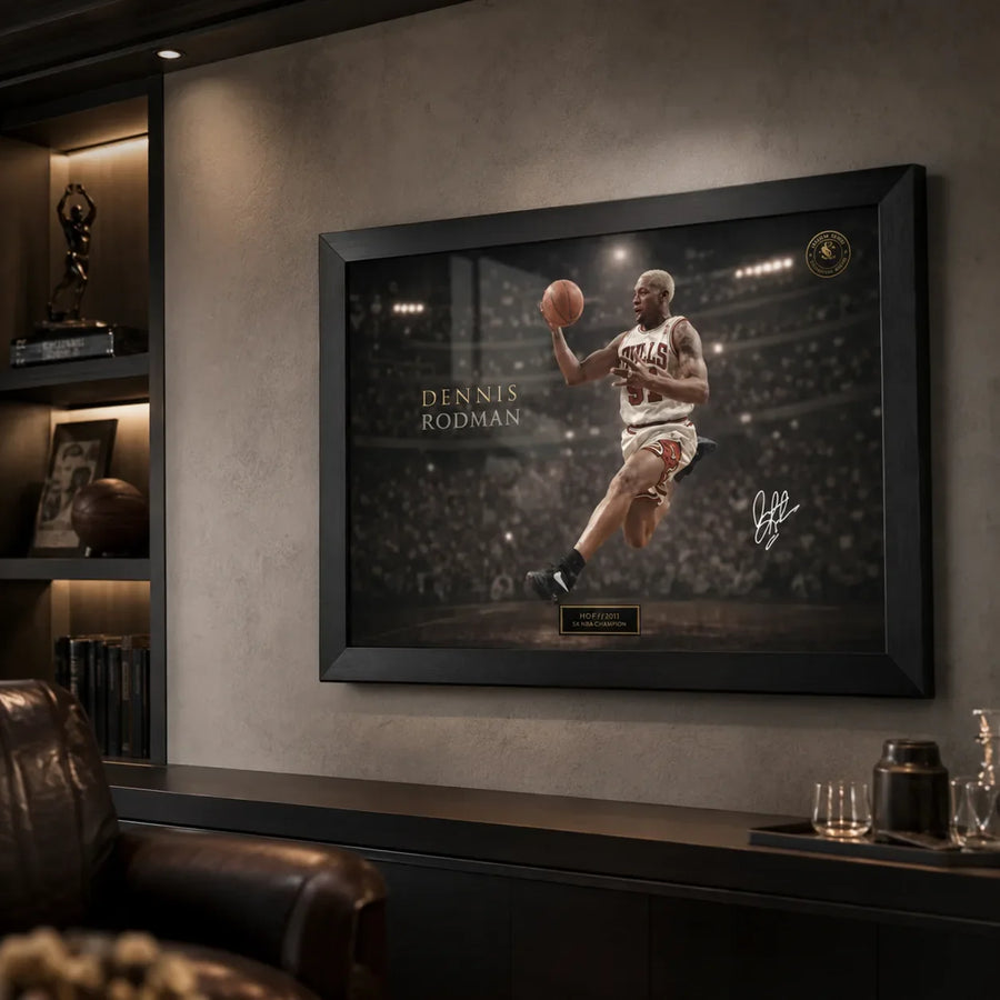 Black framed Dennis Rodman basketball wall art styled in a dark premium man cave with shelving and leather seating.