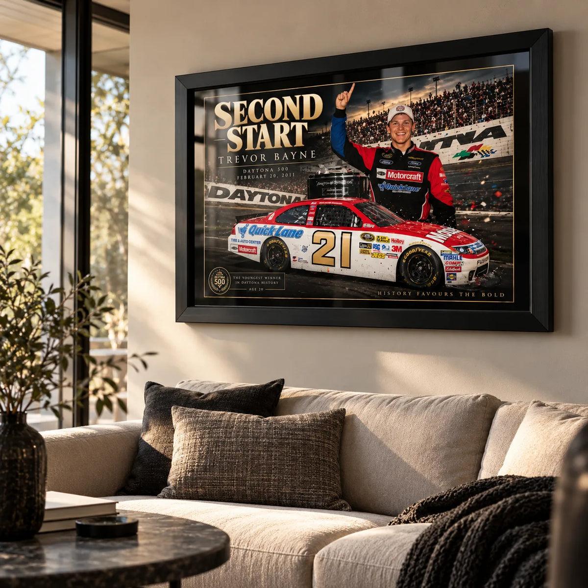 Trevor Bayne Second Start wall art displayed in a bright living room with a black frame above a neutral sofa.