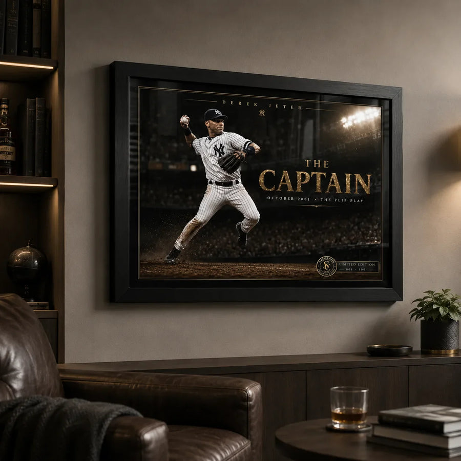 Black framed Derek Jeter The Captain baseball wall art displayed in a dark man cave with leather seating and shelving.