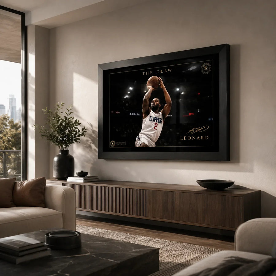 Kawhi Leonard The Claw basketball wall art in a black frame, displayed above a timber console in a modern living room.
