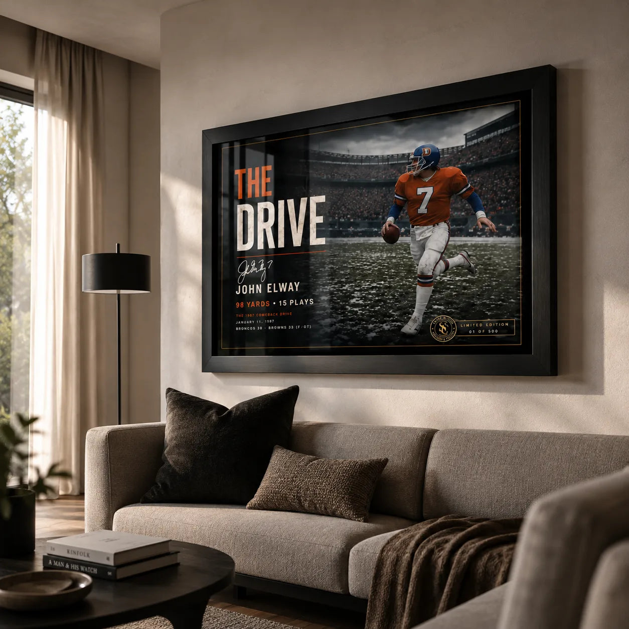 John Elway wall art displayed in a modern living room, showing The Drive collector piece in a black frame above a sofa.