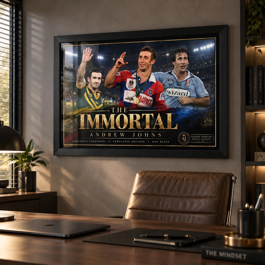 Black framed Andrew Johns rugby league wall art displayed above a desk in a modern home office with warm timber finishes.