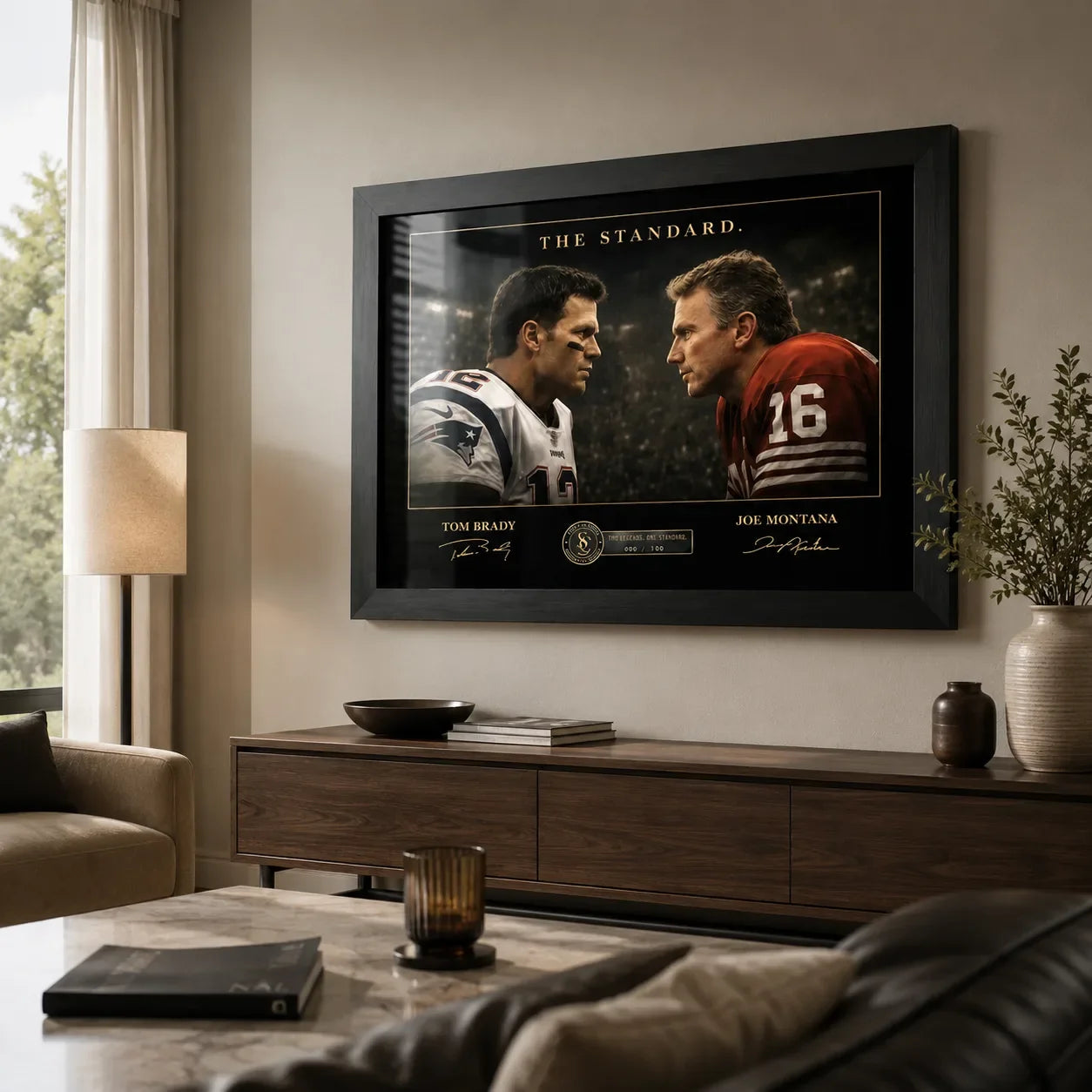 Black framed Tom Brady vs Joe Montana wall art displayed in a warm modern living room above a timber console.