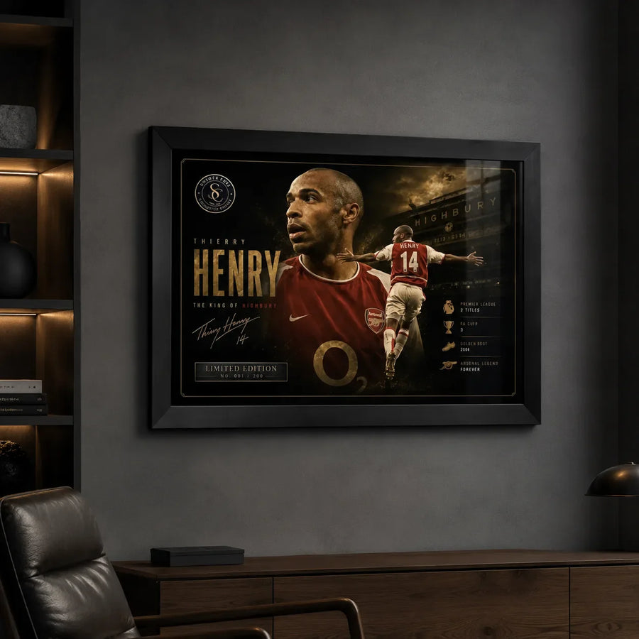 Thierry Henry Arsenal wall art in a black frame on a dark room wall with built-in shelving.