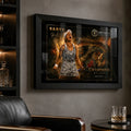 Black framed Ash Barty tennis wall art displayed in a dark man cave with shelves, leather chair and soft reflections.