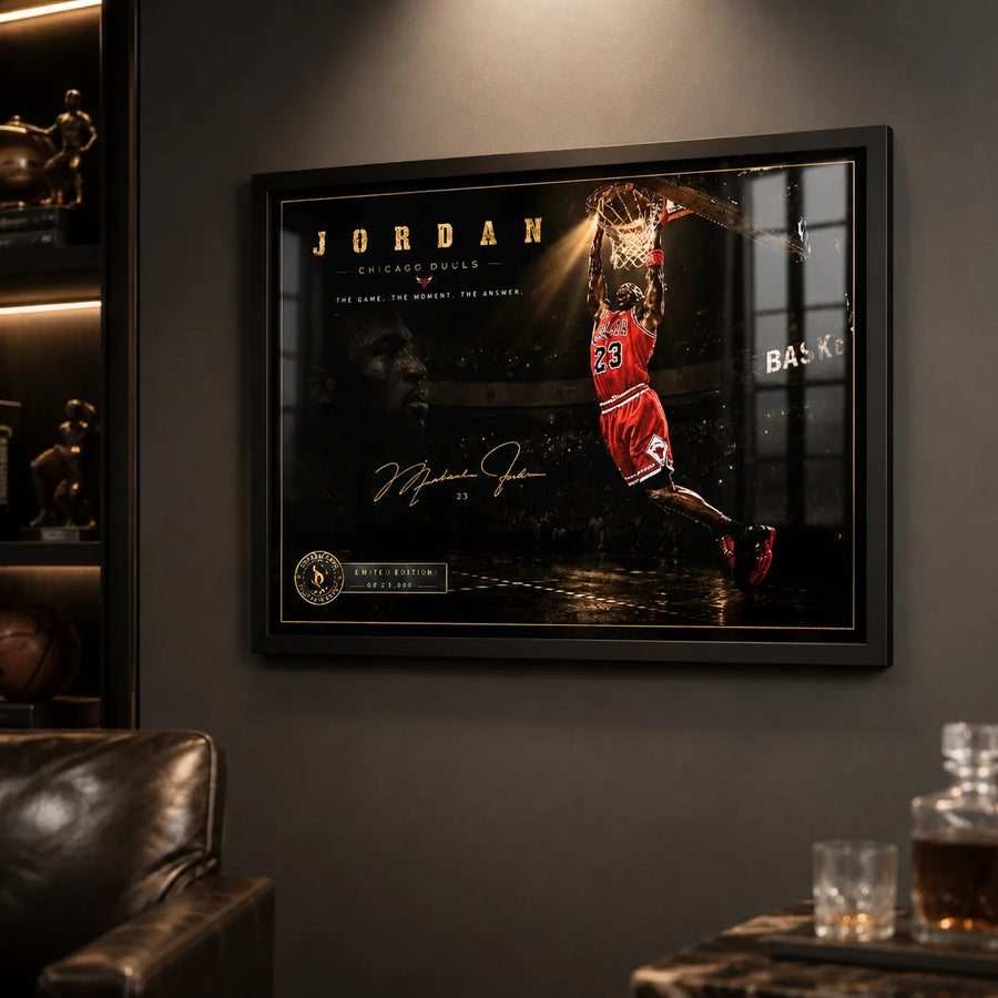 Basketball dunk wall art in a black frame on a dark man cave wall with sports memorabilia nearby.