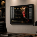 Basketball dunk wall art displayed in a black frame on a modern office wall above a wooden desk.