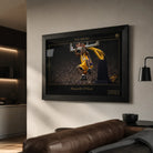 Black framed basketball wall art displayed on a warm modern living room wall above leather seating