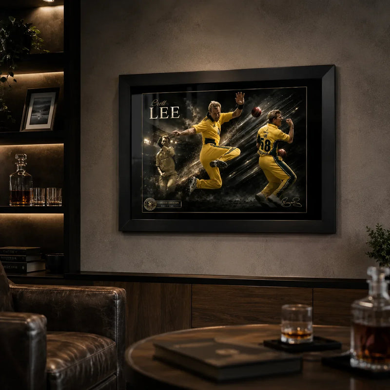 Black framed Brett Lee cricket wall art mounted in a dark collector-style man cave with illuminated shelving.