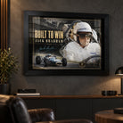 Jack Brabham Built To Win 1966 motorsport wall art in a black frame on a dark man cave wall above leather seating.
