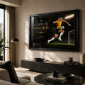Caitlin Foord soccer wall art in a black frame displayed above a low console in a modern living room.