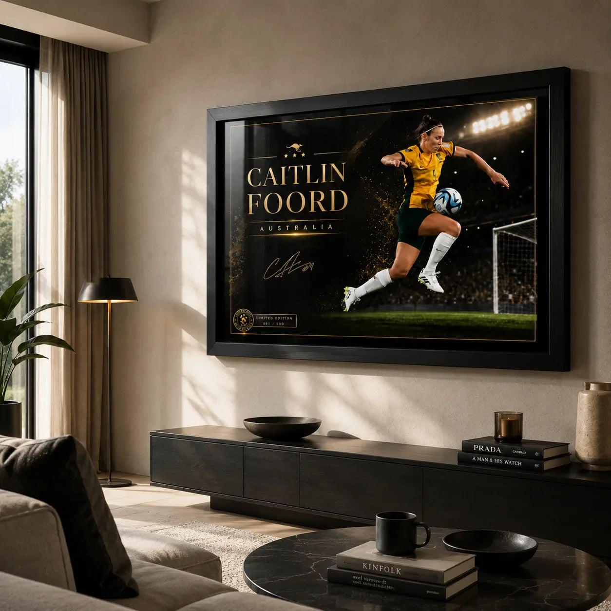 Caitlin Foord soccer wall art in a black frame displayed above a low console in a modern living room.