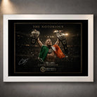 White framed Conor McGregor wall art featuring The Notorious with the Irish flag and both championship belts raised.