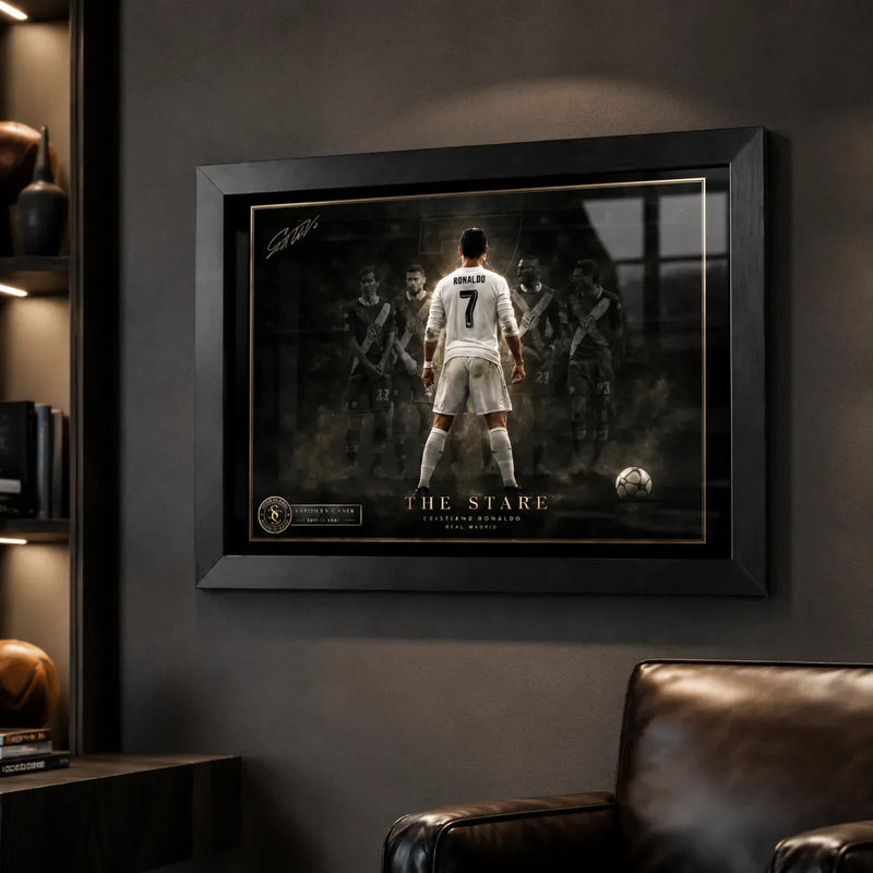 Cristiano Ronaldo football wall art in a black frame inside a dark man cave with leather chair and shelves