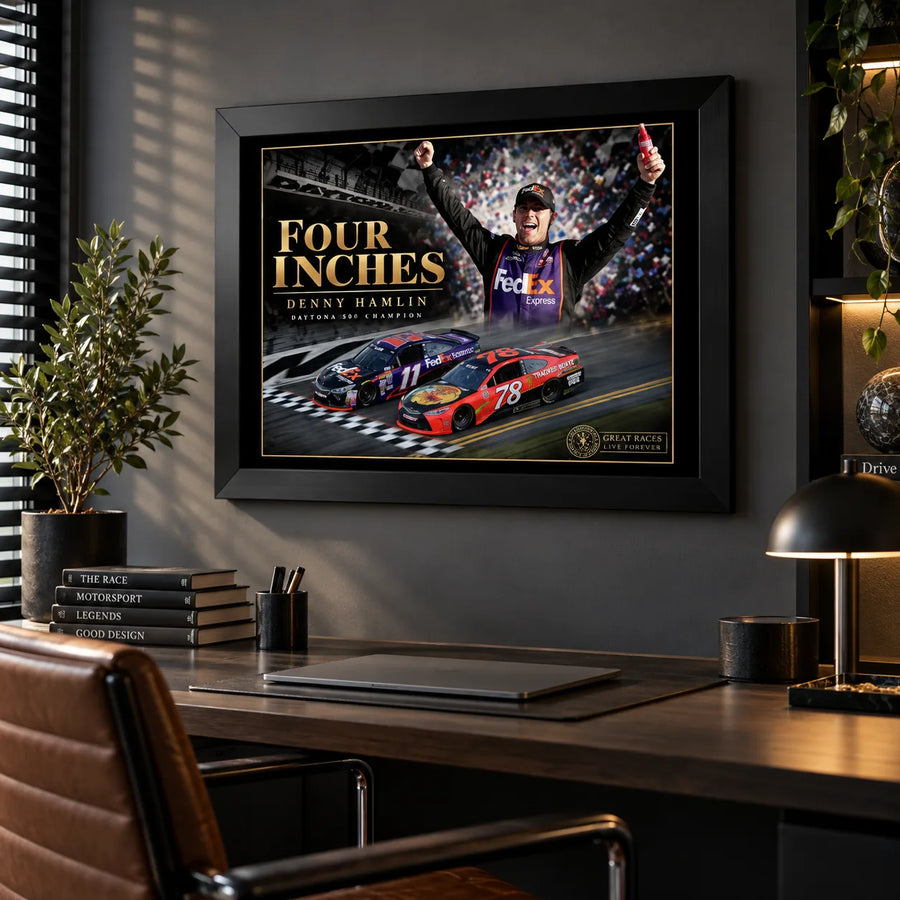 Black-framed Denny Hamlin Four Inches wall art hanging above a wooden desk in a dark modern office.
