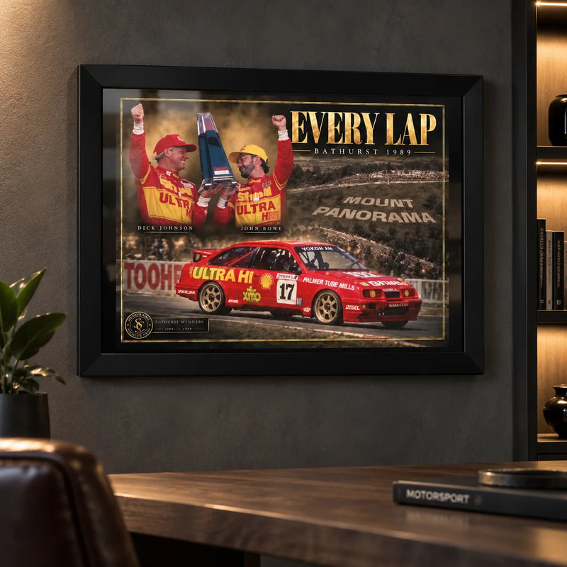 Dick Johnson and John Bowe Every Lap wall art displayed in a dark motorsport man cave with a black frame.