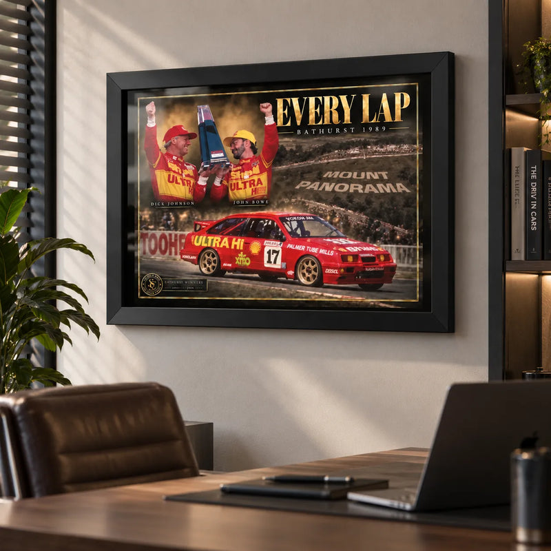 Every Lap Dick Johnson and John Bowe motorsport wall art in a modern office, shown in a black frame above the desk.