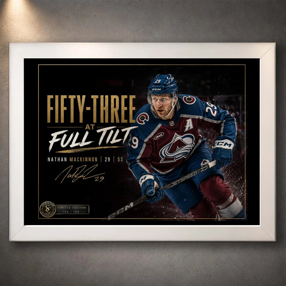 White framed Fifty-Three at Full Tilt Nathan MacKinnon hockey wall art shown against a dark textured wall.