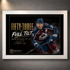 White framed Fifty-Three at Full Tilt Nathan MacKinnon hockey wall art shown against a dark textured wall.