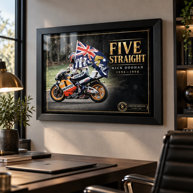 Mick Doohan Five Straight motorsport wall art displayed in a modern office with black frame and warm ambient lighting.