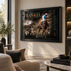 Frankel horse racing wall art in a black frame displayed on a contemporary living room wall with neutral furniture and greenery.