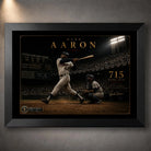 Hank Aaron 715th home run baseball wall art shown in a premium black frame against a softly lit concrete wall.