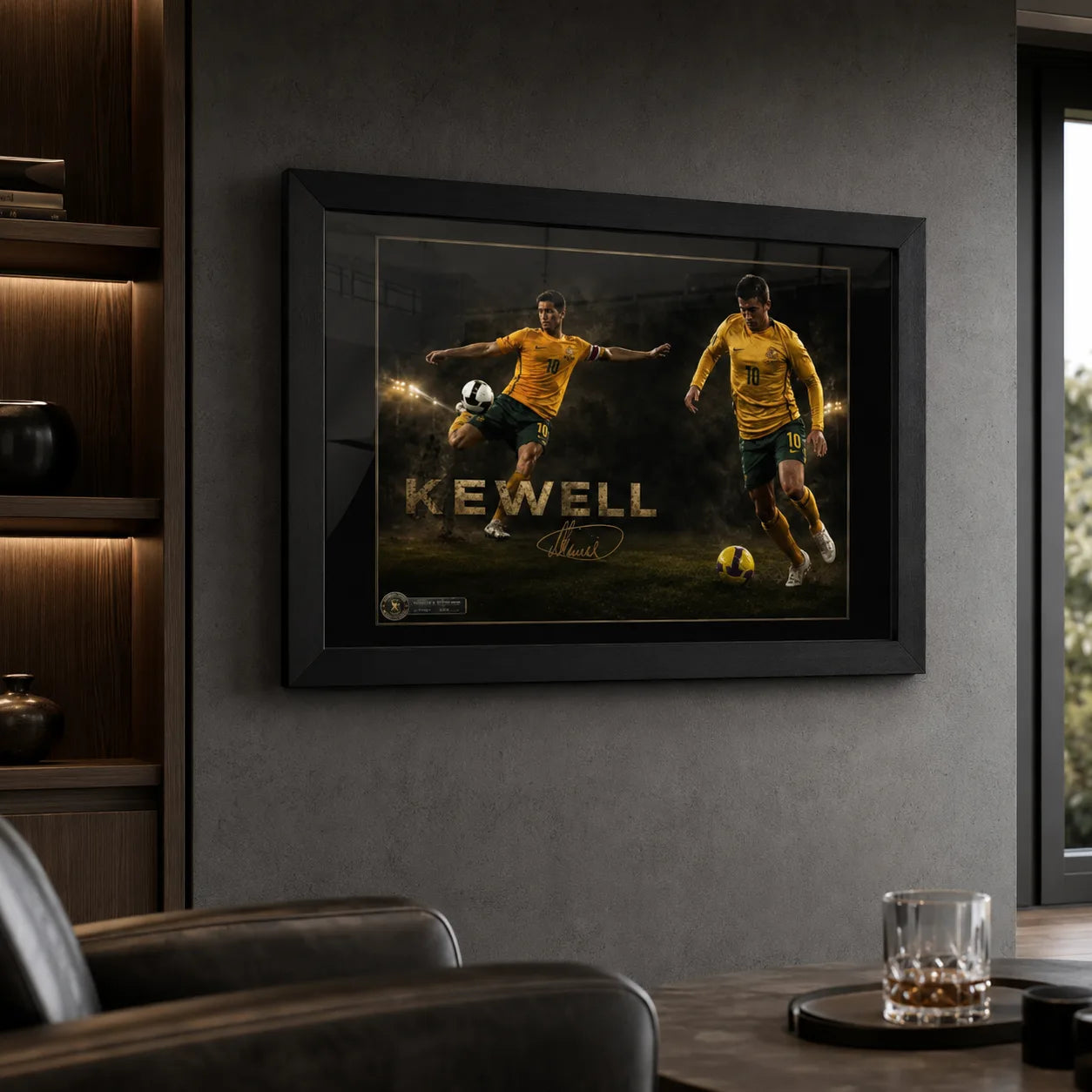 Black framed Harry Kewell soccer wall art displayed in a dark man cave with leather seating and illuminated shelving.
