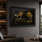 Black framed Harry Kewell soccer wall art displayed in a dark man cave with leather seating and illuminated shelving.