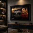 Black framed Jason Richards motorsport wall art displayed in a dark man cave with racing memorabilia and leather seating.