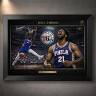 Joel Embiid 76ers NBA wall art shown in a black frame with gold trim and arena action artwork.