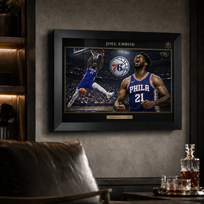 Framed Joel Embiid 76ers basketball artwork displayed in a dark man cave lounge setting.