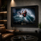Kelly Slater surfing wall art in a black frame displayed in a dark man cave with warm shelving and a leather chair.