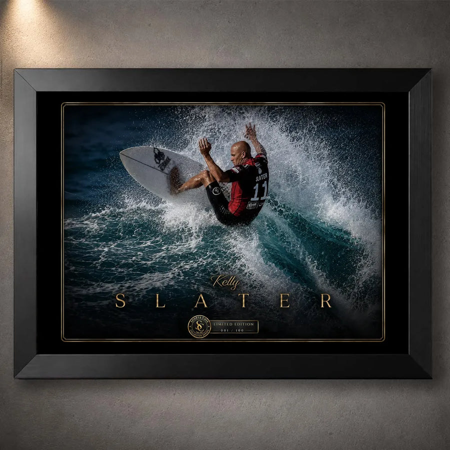 Black framed Kelly Slater surfing wall art showing a powerful turn through a breaking wave in a black and gold collector design.