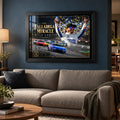 Kyle Larson The Talladega Miracle edition in a black frame above a fabric sofa against a blue living room wall.