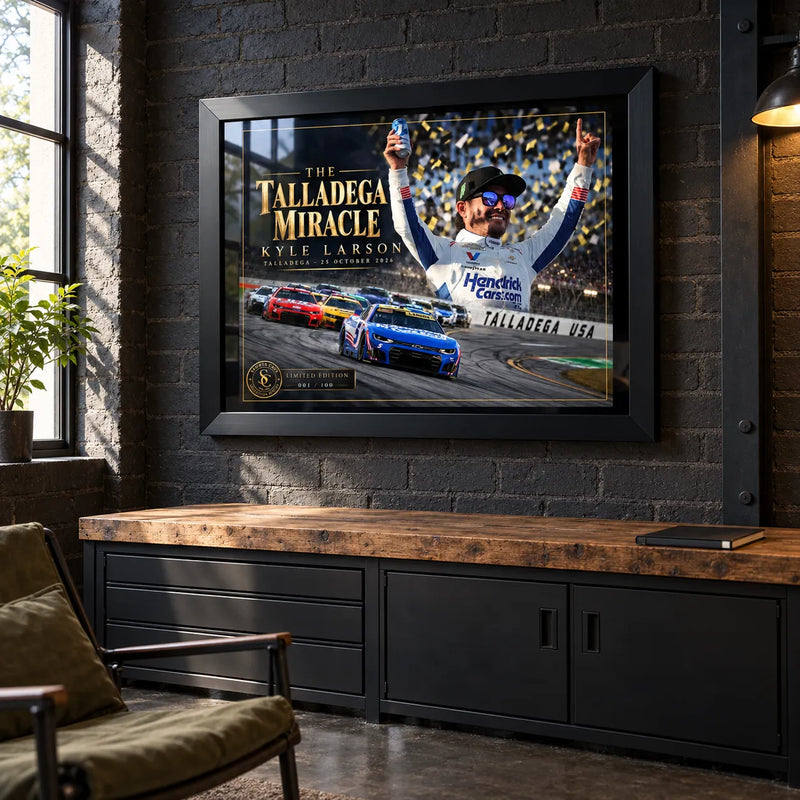Kyle Larson The Talladega Miracle edition in a black frame on a dark brick man cave wall above timber cabinetry.